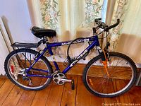 Side view of the full CCM North Ridge mountain bike showing frame, wheels, saddle, and front suspension.