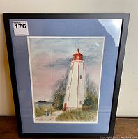 Framed print of Historic Port Burwell Lighthouse with full view including black frame and blue matting.