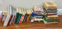 Wide shot showing a large assortment of books in stacks and rows against a wall, topics including healing, medicine, plants, cooking, self help
