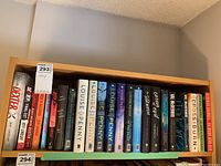 Books on shelf in two rows showing titles by Jeff Lindsay, Louise Penny, and Robert Galbraith