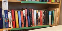Shelf of various paperback books, colorful spines including some classic and popular titles.