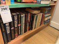 Shelf view showing a variety of books including John Grisham novels and other titles