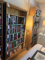 Front view of handmade pine bookshelf filled with books showing natural wood finish and decorative top molding.