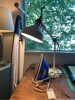 Photo of Proctor Silex ClearSteam iron with cord, lamp, power bar on tabletop under window