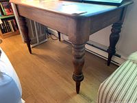 Side view of wooden table showing turned legs and rectangular top