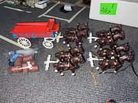 Cast iron red wagon, four sets of brown cast iron horses and bag with drivers.