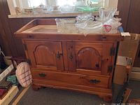 Wooden dry sink cabinet with two doors and dovetail drawer, items on top removed, showing top with light metal tray insert and some glassware removed as per seller's note.