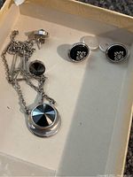 Silver-tone necklace and black faceted stud earrings in a box