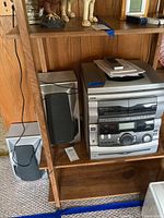 The stereo system and two speakers on wooden shelving unit