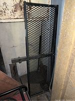 Black metal rectangular platform with diamond mesh surface, tubular frame, and hitch receiver tube with locking pin hole for mounting to a trailer hitch.