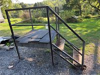 Full view of the outdoor platform steps showing metal frame, wood steps, landing with metal mesh and plates, and handrails.