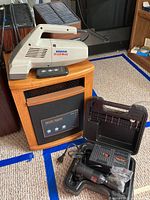 Hoover Brush Vac handheld vacuum on top of Sun-Twin infrared heater cabinet next to Black & Decker rotary tool in case.
