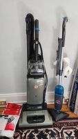 Hoover Windtunnel vacuum and Bissell Steammop Select shown side by side against white wall