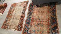 Two vintage rugs shown side by side on floor, showing overall condition and pattern.