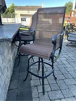 Side view of brown mesh swivel bar-height stool with metal frame