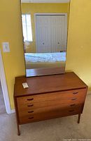 Full view of wood dresser with attached rectangular mirror