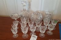 Full collection of 15 Pinwheel pattern glassware pieces arranged on wooden surface, including decanter, punch bowl, glasses, vase, and compote dish.