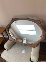 Full view of wood framed mirror showing its size and curved frame shape.