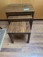 All three wooden nesting tables stacked with largest at bottom
