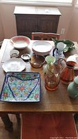 Overview of entire lot on table including pitchers, plates, bowls, ashtray, and serving plates