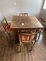 Overview of square table in closed position with four chairs around it
