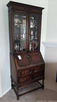 Full front view of oak secretary desk with glass display cabinet on top