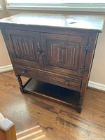 Full front view of dark brown cabinet showing doors, drawer and open shelf