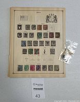 Page of India postage stamps dated 1855-1913 with various designs and postmarks, accompanied by a small plastic bag with four loose stamps.