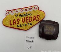 A photo showing the beaded Las Vegas Nevada coin purse and vintage Virginia Slims compact mirror side by side.