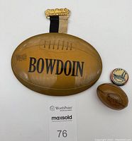 Front view of two metal football pins and attached WWII pinback button