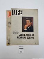 Front covers of two vintage Life magazines, one featuring John F. Kennedy Memorial Edition 1963 and the other with partial view of the 1972 issue.