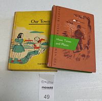 The two vintage reading books showing front covers: 'Our Town' and 'The New Basic Readers' More Times and Places.