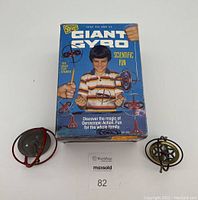 Front view of new in box Giant Gyro toy with packaging and two used Giant Gyro toys beside it.