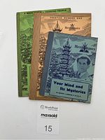 Three vintage metaphysical books stacked together, showing color-coded covers: green, brown, and blue-green with illustration and text.