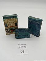 Three vintage tobacco tins photographed on white background showing Bond Street and two Edgeworth tins.
