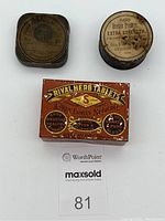 Three vintage tins shown: rectangular red Rival Herb Tablets tin in front with a round Berdan Primers Extra Strength tin and a square Elgin National Watch Co. tin behind them