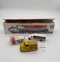 All four toy trucks grouped together: Exxon truck in original box, Dinty Moore truck boxed, yellow Kraft Miracle Whip truck, and white Pepsi truck.