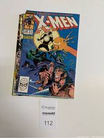 Full view of the top comic book showing The Uncanny X-Men Vol.1 No.249 cover with characters and vibrant colors