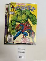 Front view of stacked Amazing Spider-Man comic books with cover art featuring Spider-Man and the Hulk.