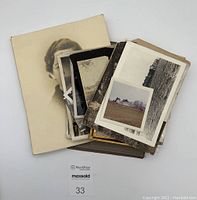 Pile of various vintage black and white photographs and prints, including portraits and outdoor scenes