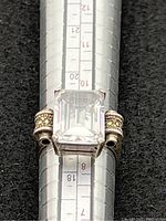 Front view of sterling silver ring with large emerald cut clear stone on ring sizing mandrel showing size 8.5.