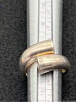 Close-up of the sterling silver wrap ring sized on ring mandrel showing size around 7.5 with visible tarnish and wear.