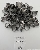 Pile of vintage aluminum toy rings shaped like western horse saddles, showing detailed molded saddle design.