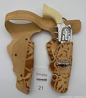 Full view of the camel plastic holster with attached toy cap revolver and belt strap.