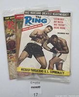 Three vintage The Ring boxing magazines in plastic bag, front issue is December 1969 special collectors issue showing two boxers in match action on cover.