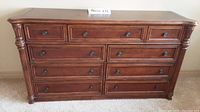 Front view of Bassett nine-drawer lowboy dresser showing decorative drawer fronts and rounded metal knobs.