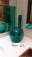 Three aqua handmade glass vases including two tall smooth cylinders and one round crackle finish sphere vase.