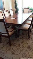 Overall side view of dark wood dining table and eight chairs