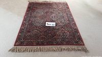 Full view of the Kirman area rug showing overall pattern and fringes.