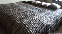 Brown patterned Madison Park king size comforter with floral and geometric designs spread on bed with matching shams and decorative pillows arranged on top.